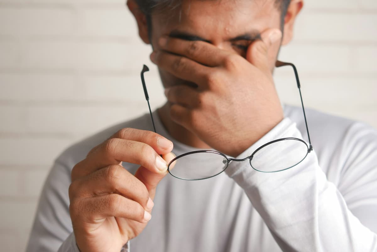 Pessoa esfregando os olhos por causa de coceira e olho seco